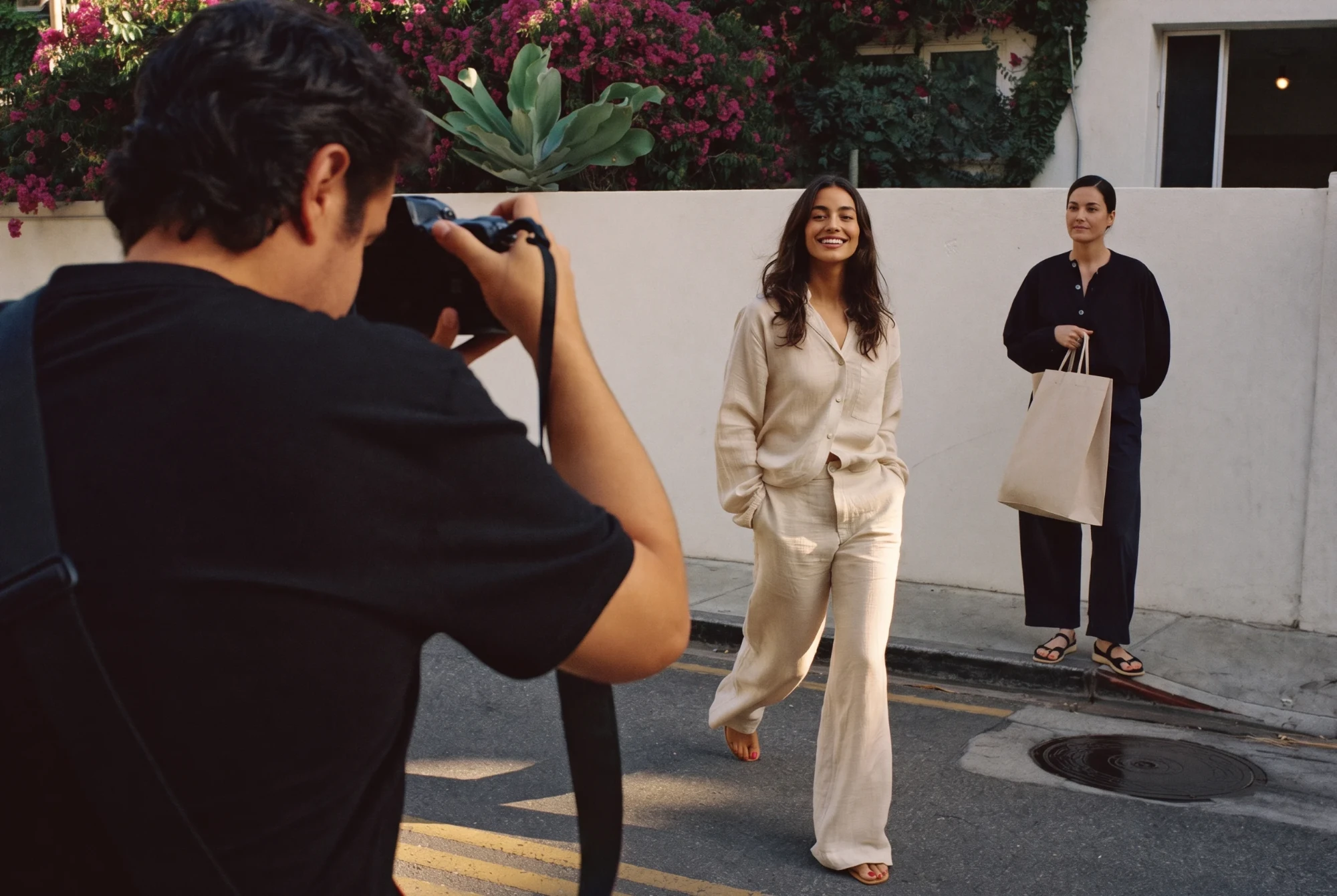 Outdoor editorial photo shoot with a photographer and two people.